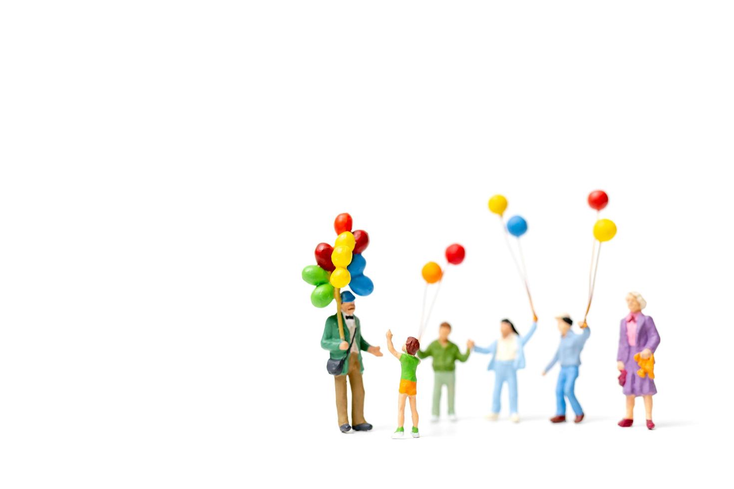 persone in miniatura in possesso di palloncini isolati su uno sfondo bianco foto