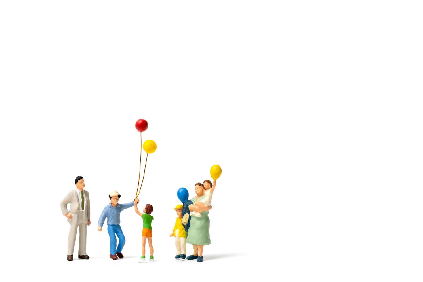 persone in miniatura in possesso di palloncini isolati su uno sfondo bianco foto