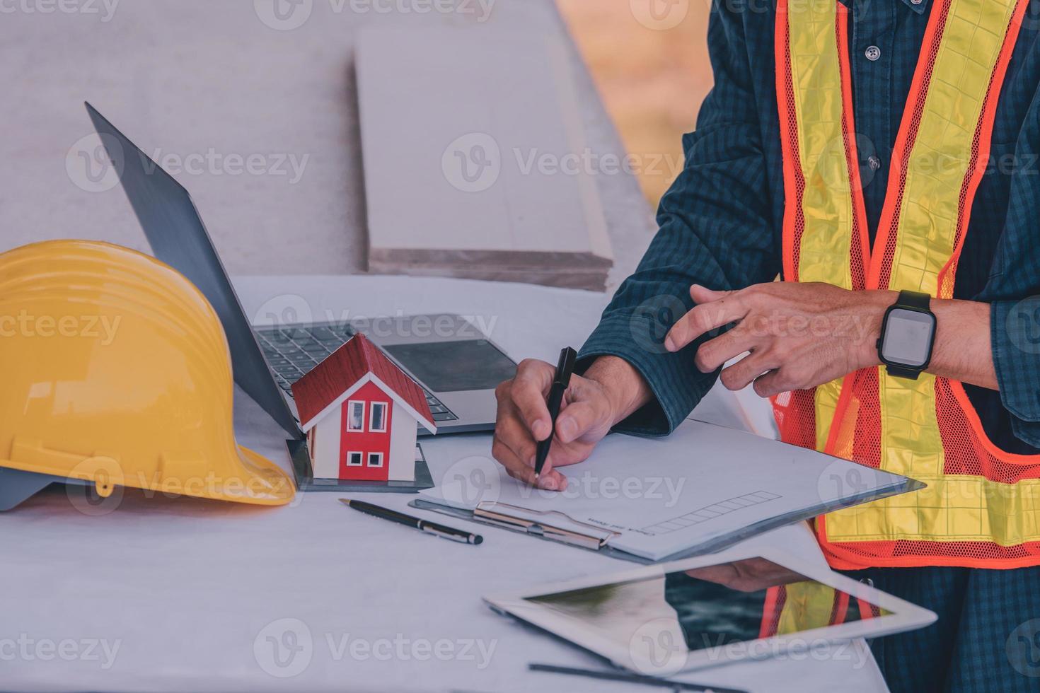 ingegnere che lavora su tablet e laptop in cantiere foto