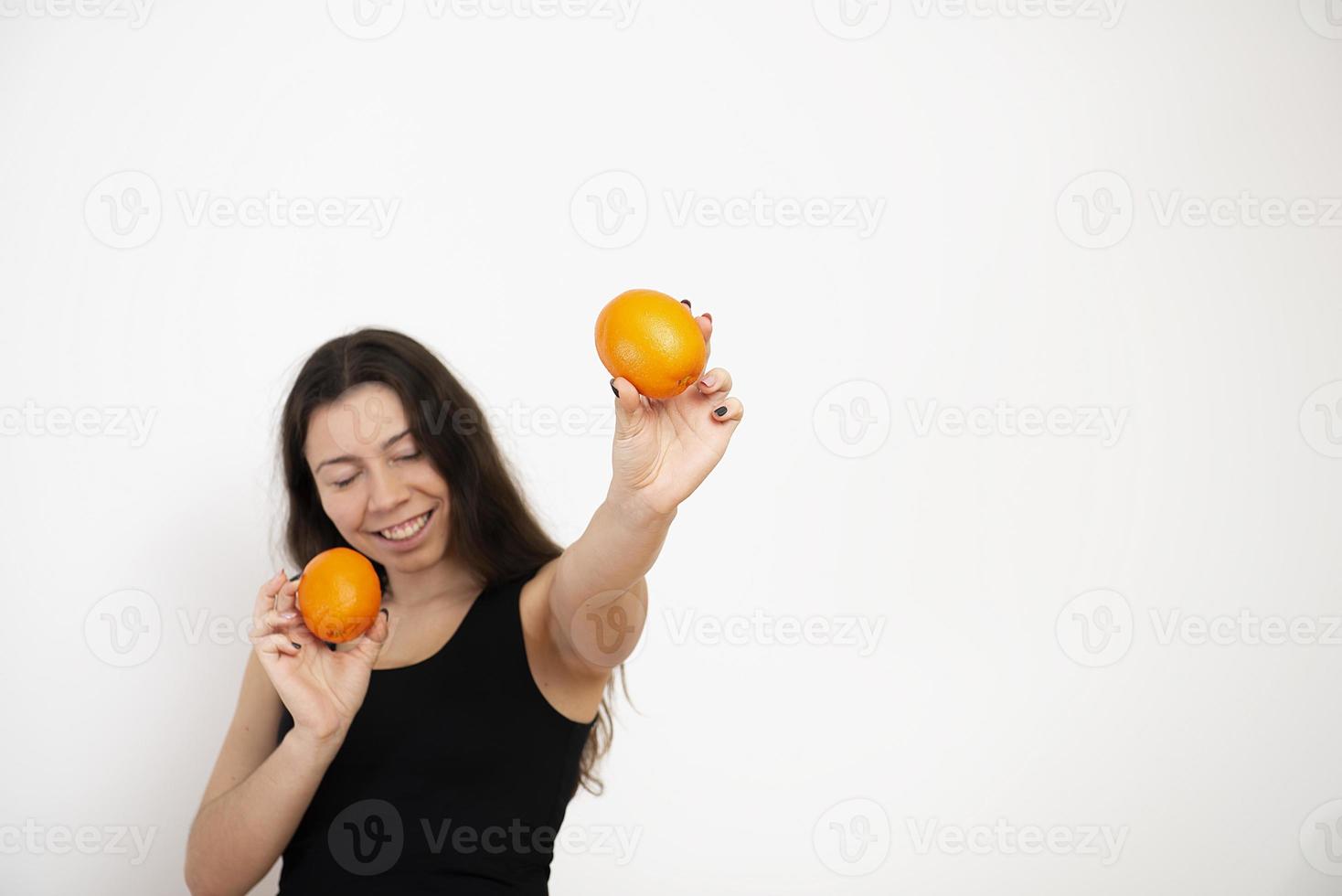 donna felice che tiene in mano frutta arancione foto