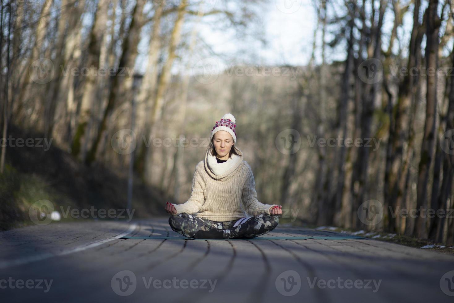 una giovane donna atletica esegue esercizi di yoga e meditazione all'aperto foto