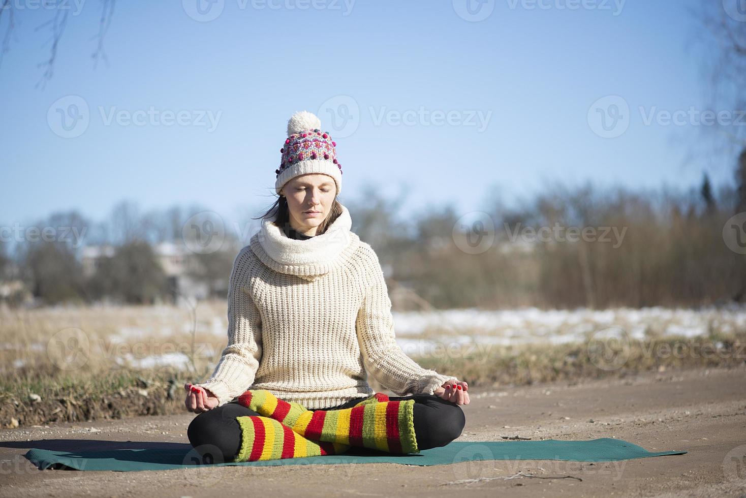 una giovane donna atletica esegue esercizi di yoga e meditazione all'aperto foto