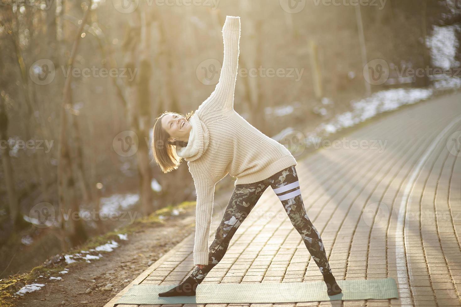una giovane donna atletica esegue esercizi di yoga e meditazione all'aperto foto