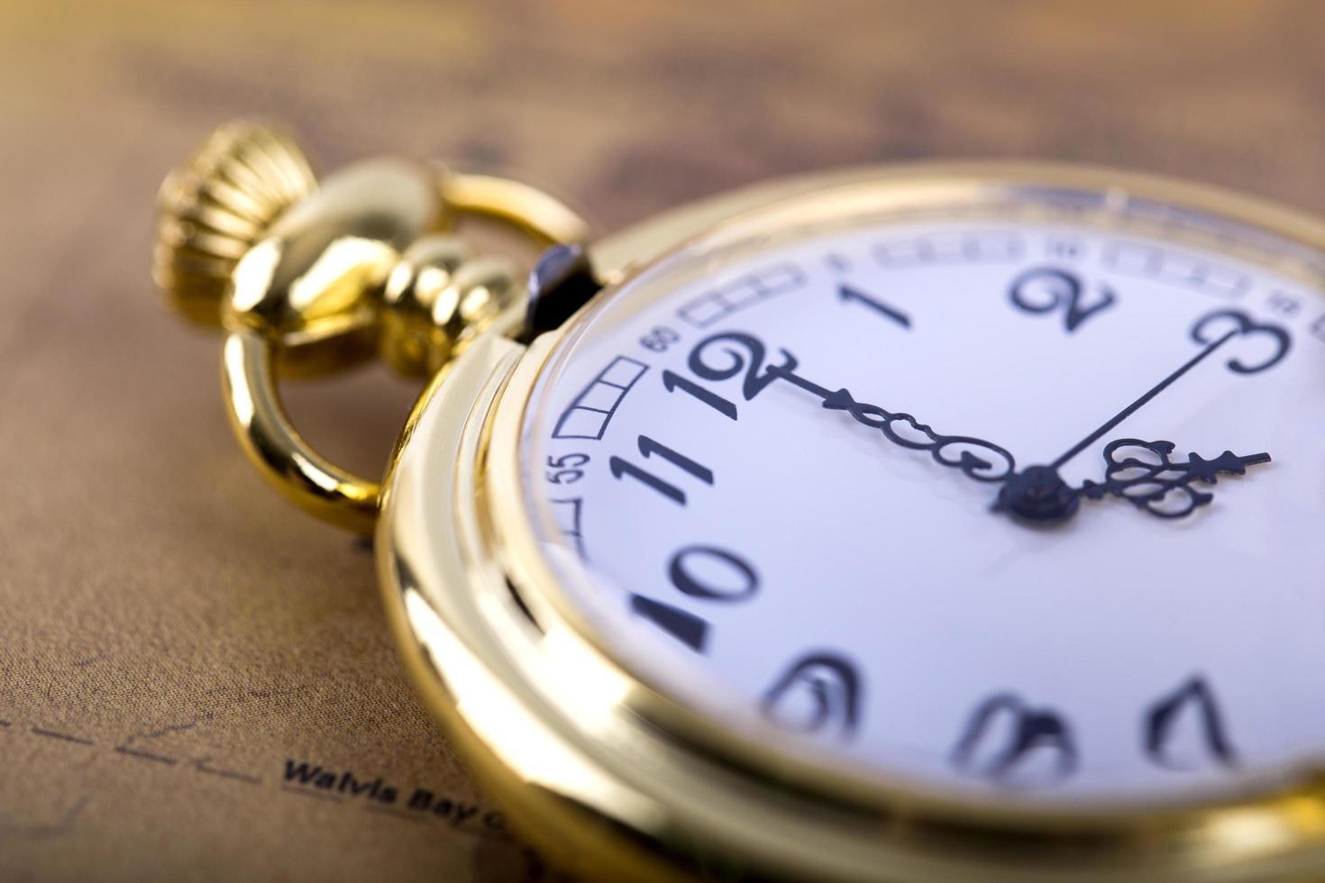 primo piano di un orologio da tasca d'oro foto