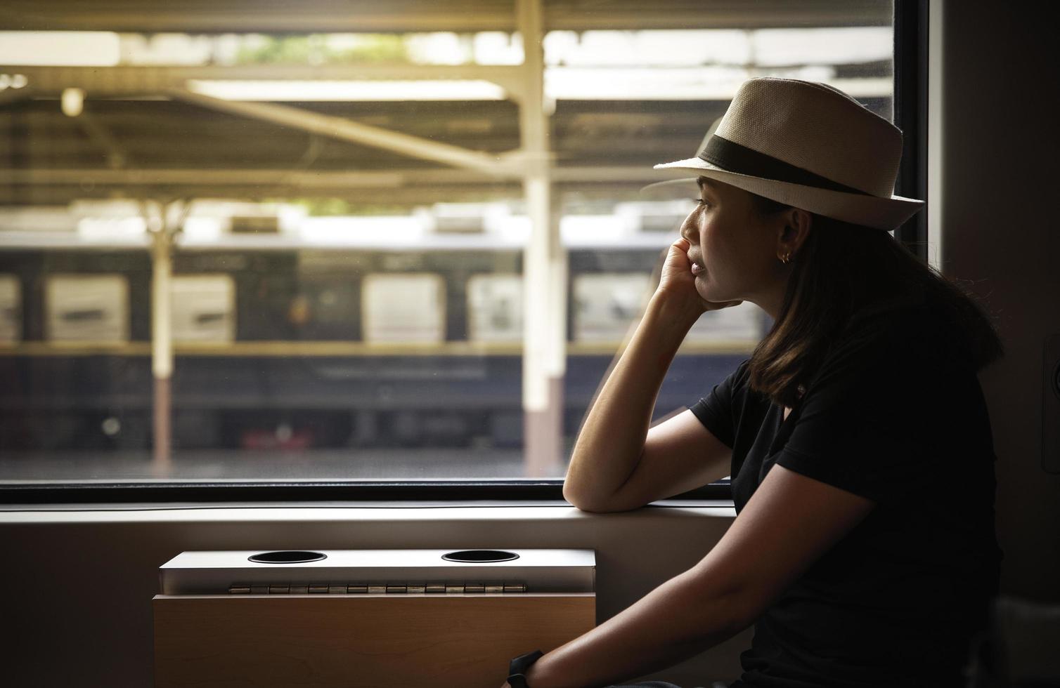 donna che guarda fuori dal finestrino del treno foto