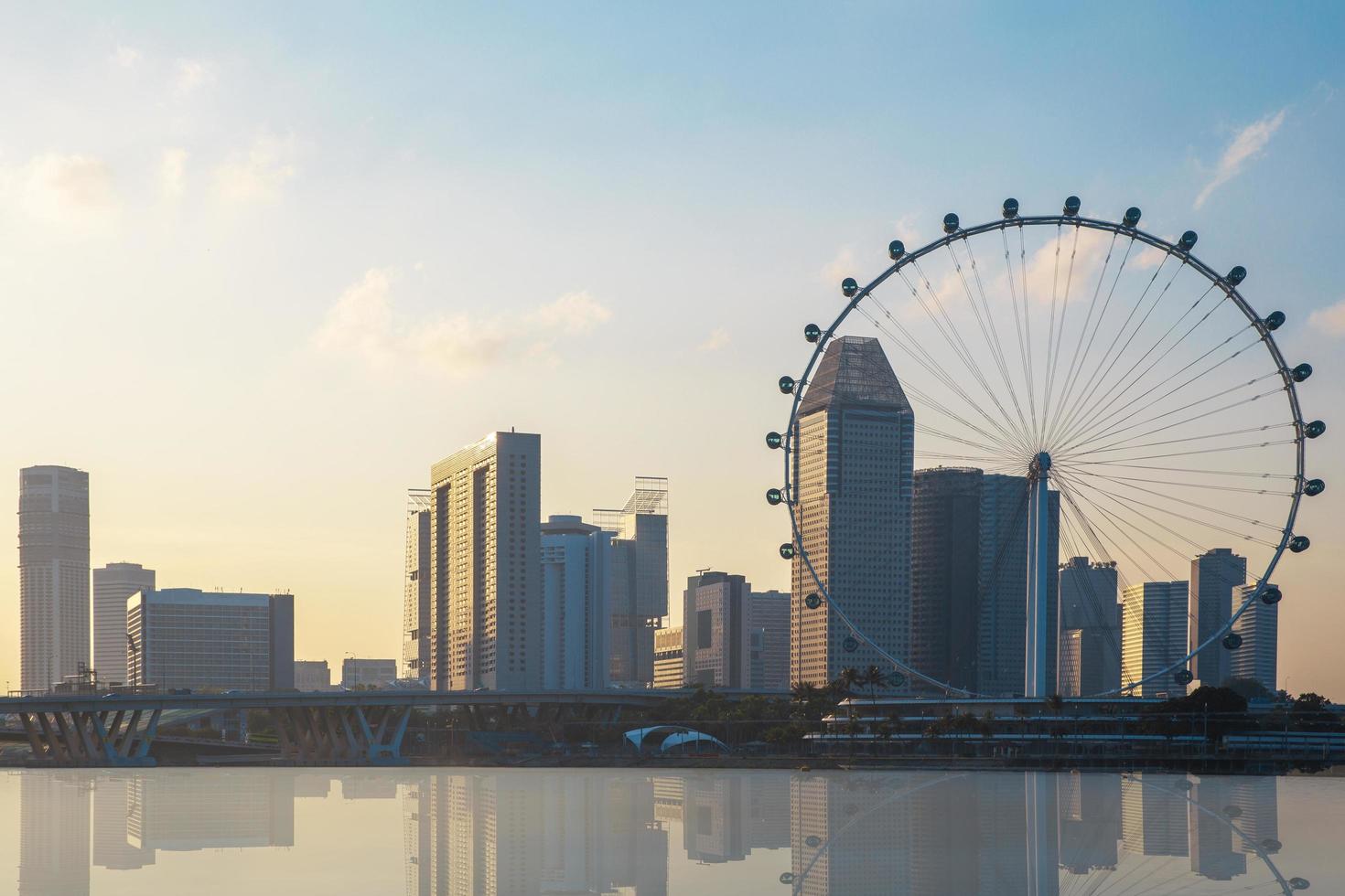 singapore, 2021 - ruota panoramica gigante e paesaggio urbano al tramonto foto