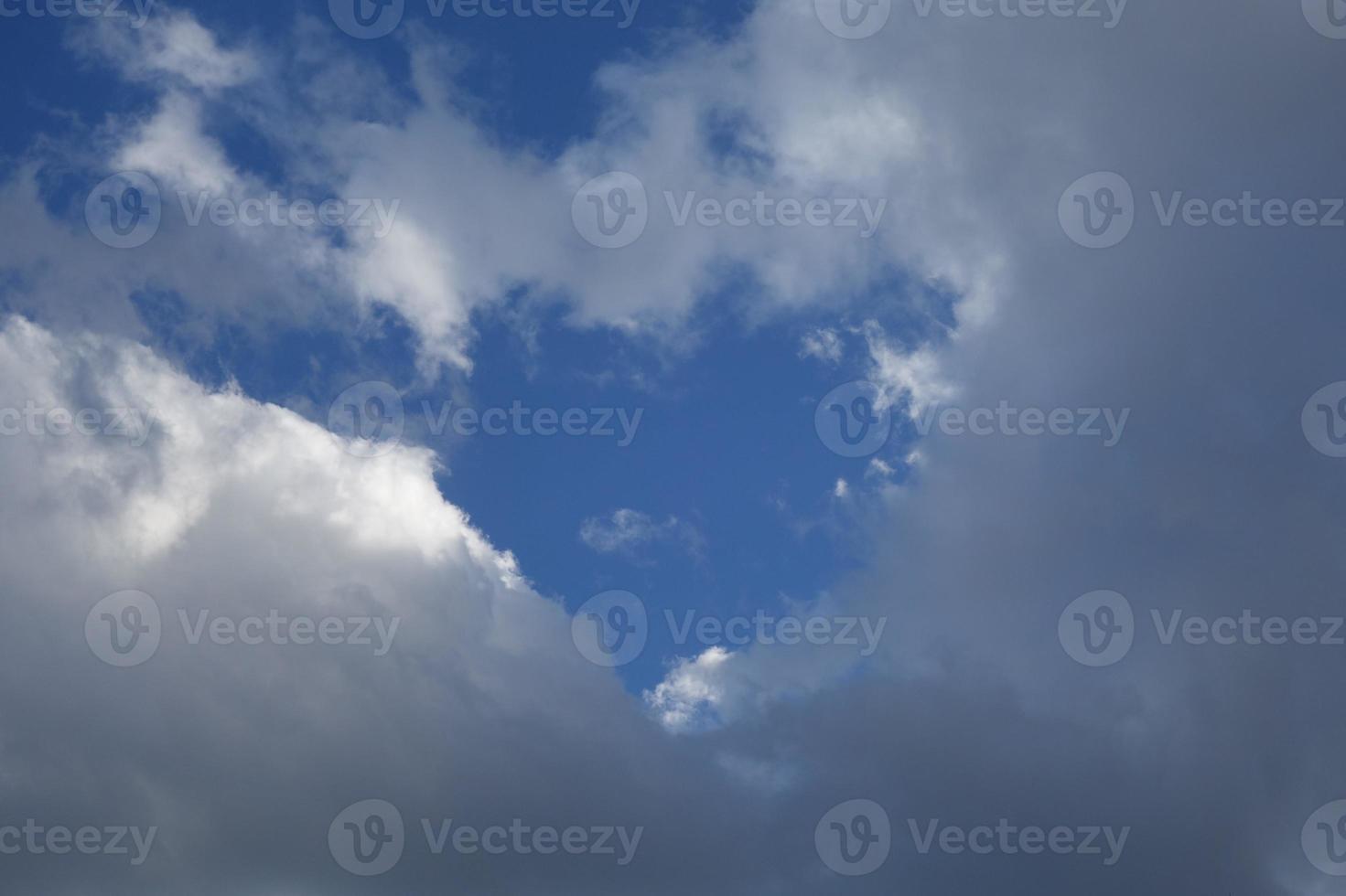 bianca nuvole formatura un' cuore a il blu cielo foto