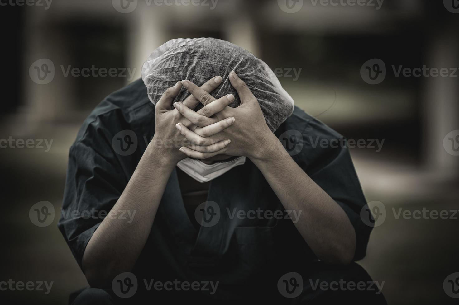 stanco depresso donna asiatica scrub infermiera indossa maschera facciale uniforme blu siede sul pavimento dell'ospedale, giovane donna medico stressato dal duro lavoro foto