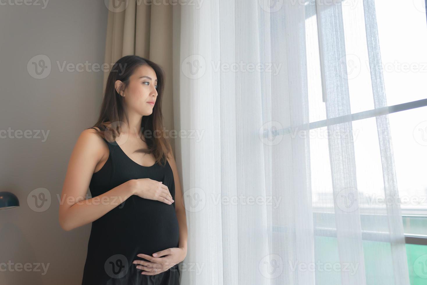 ritratto di asiatico incinta donna nel il Camera da letto foto