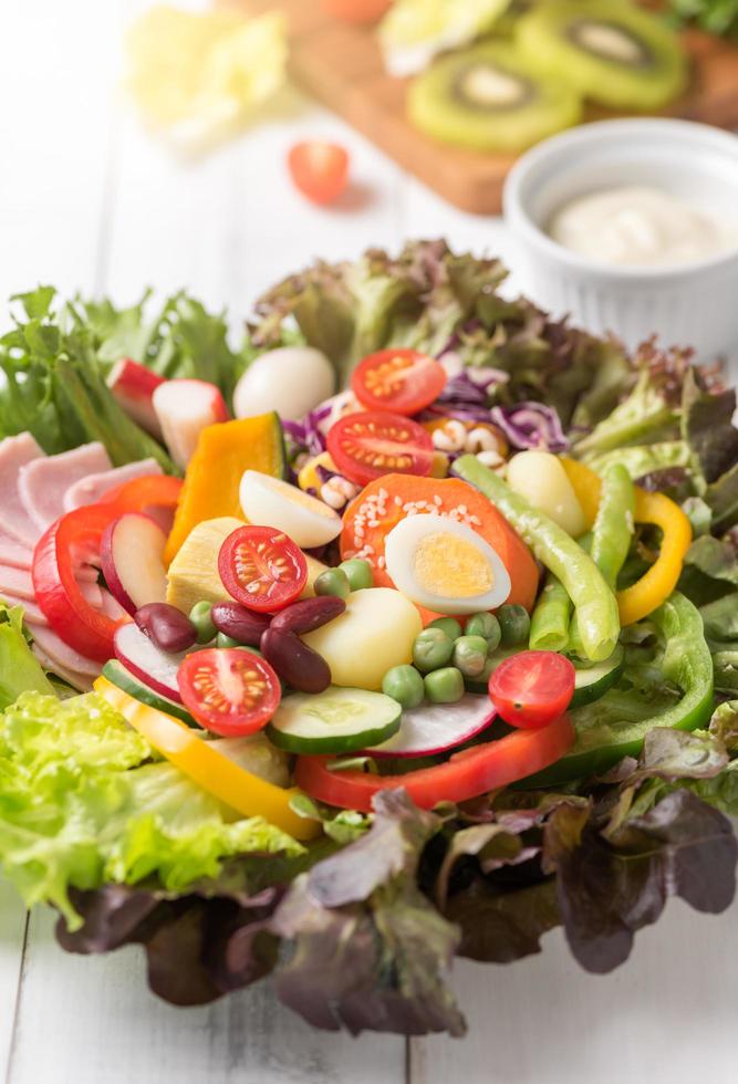 chiuso su di fresco mescolare vegetazione insalata su bianca legna sfondo. foto