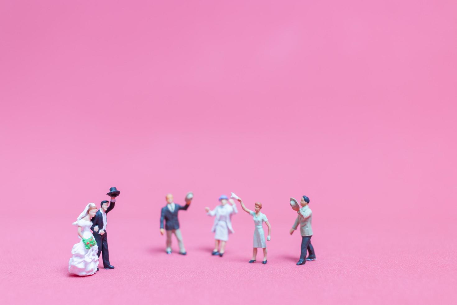 matrimonio in miniatura, una sposa e lo sposo su uno sfondo rosa foto