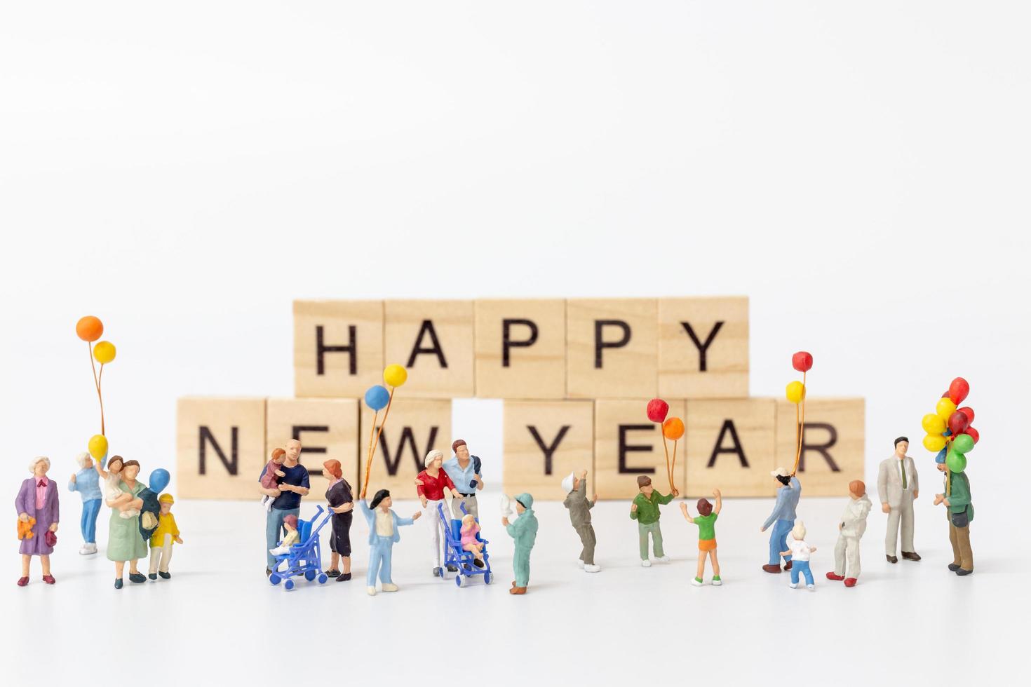 famiglie in miniatura su blocchi di legno con il testo felice anno nuovo su uno sfondo bianco foto