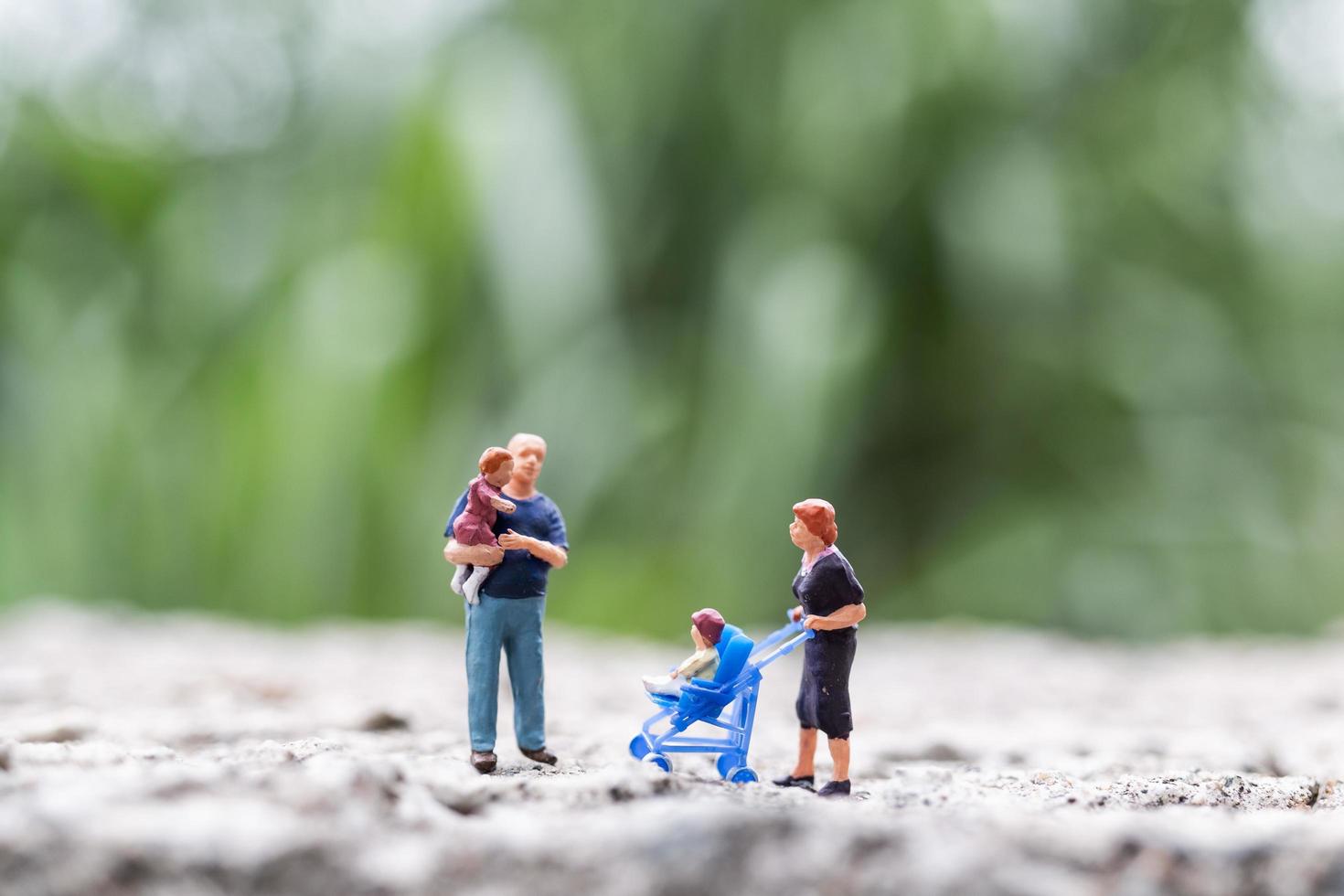 genitori in miniatura con bambini che camminano all'aperto, concetto di famiglia felice foto