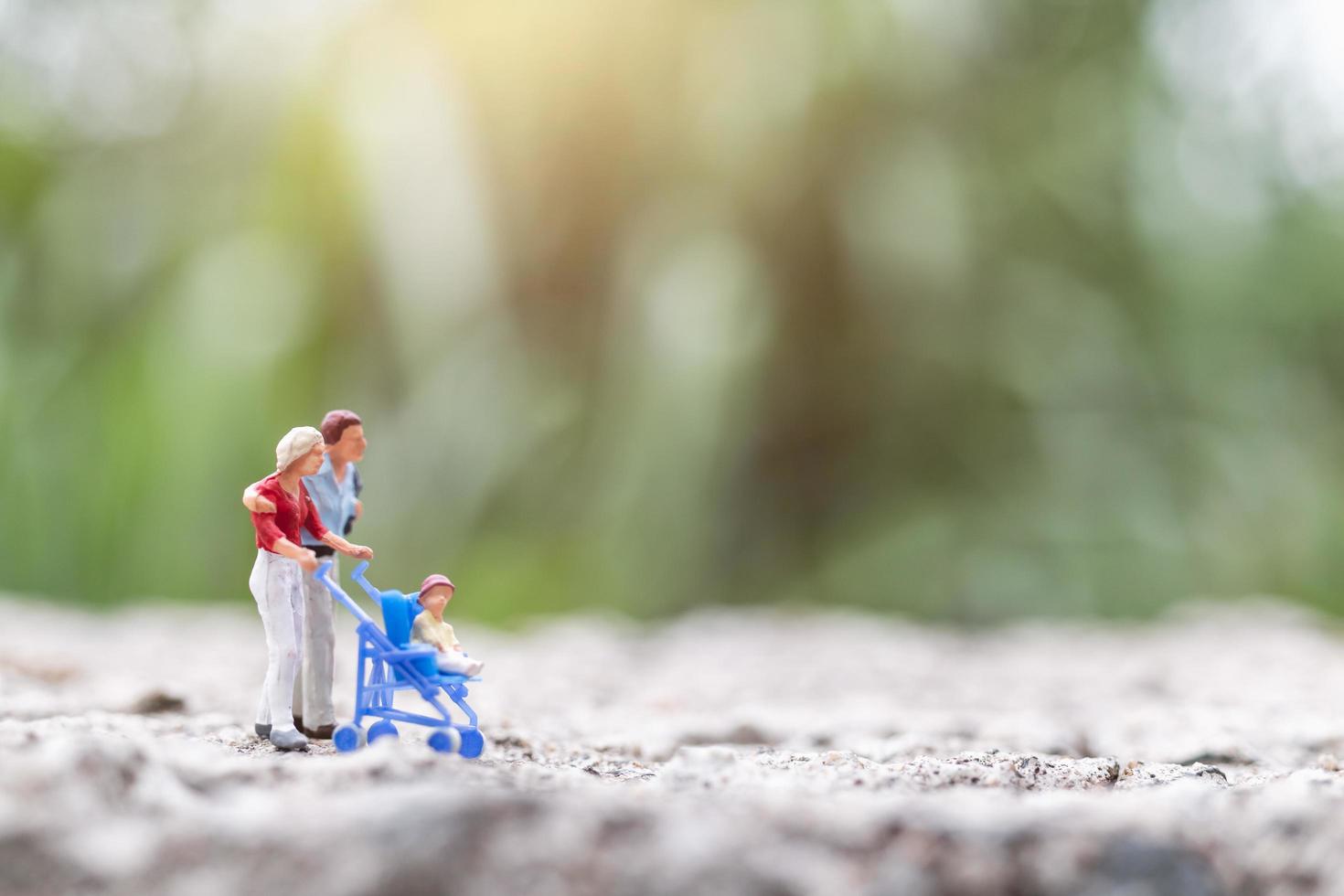 genitori in miniatura con bambini che camminano all'aperto, concetto di famiglia felice foto