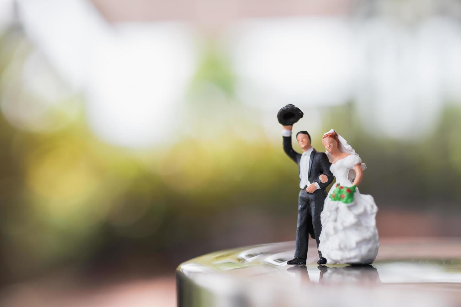 coppia di sposi in miniatura in piedi su un palco, concetto di matrimonio foto