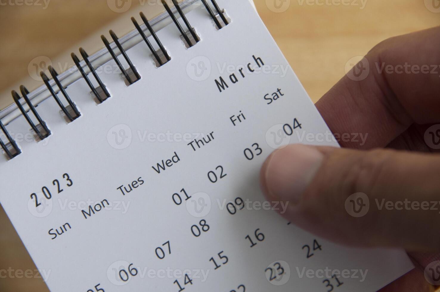 superiore Visualizza di mano capovolgimento marzo 2023 calendario. calendario concetto foto