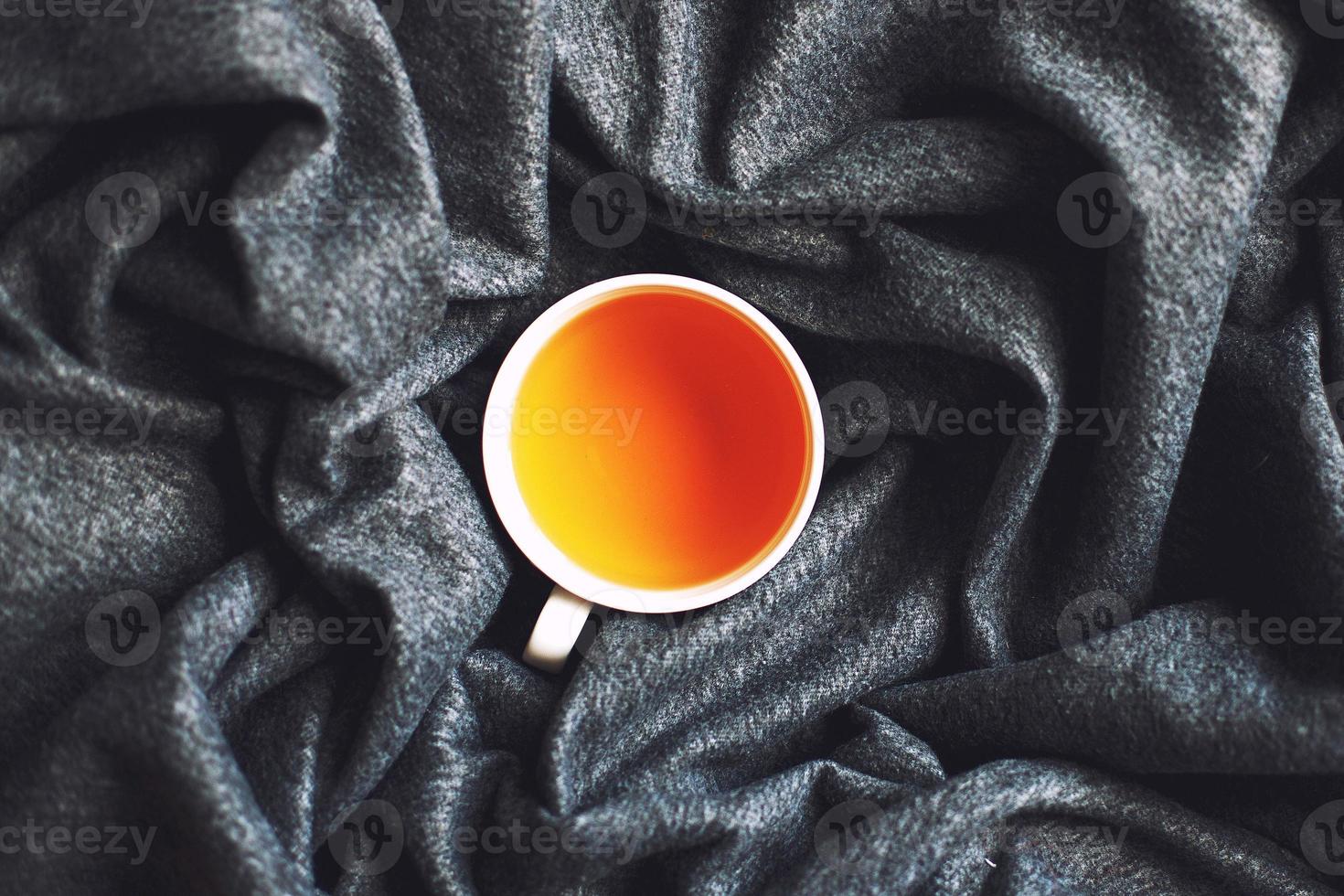 tazza di caldo tè su un' grigio morbido plaid chiudere. superiore Visualizza foto