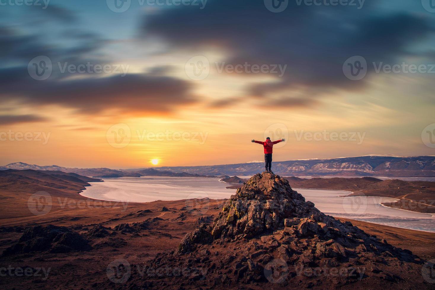 viaggiatore uomo indossare rosso Abiti e raccolta braccio in piedi su montagna a tramonto nel lago baikal, Siberia, Russia. foto