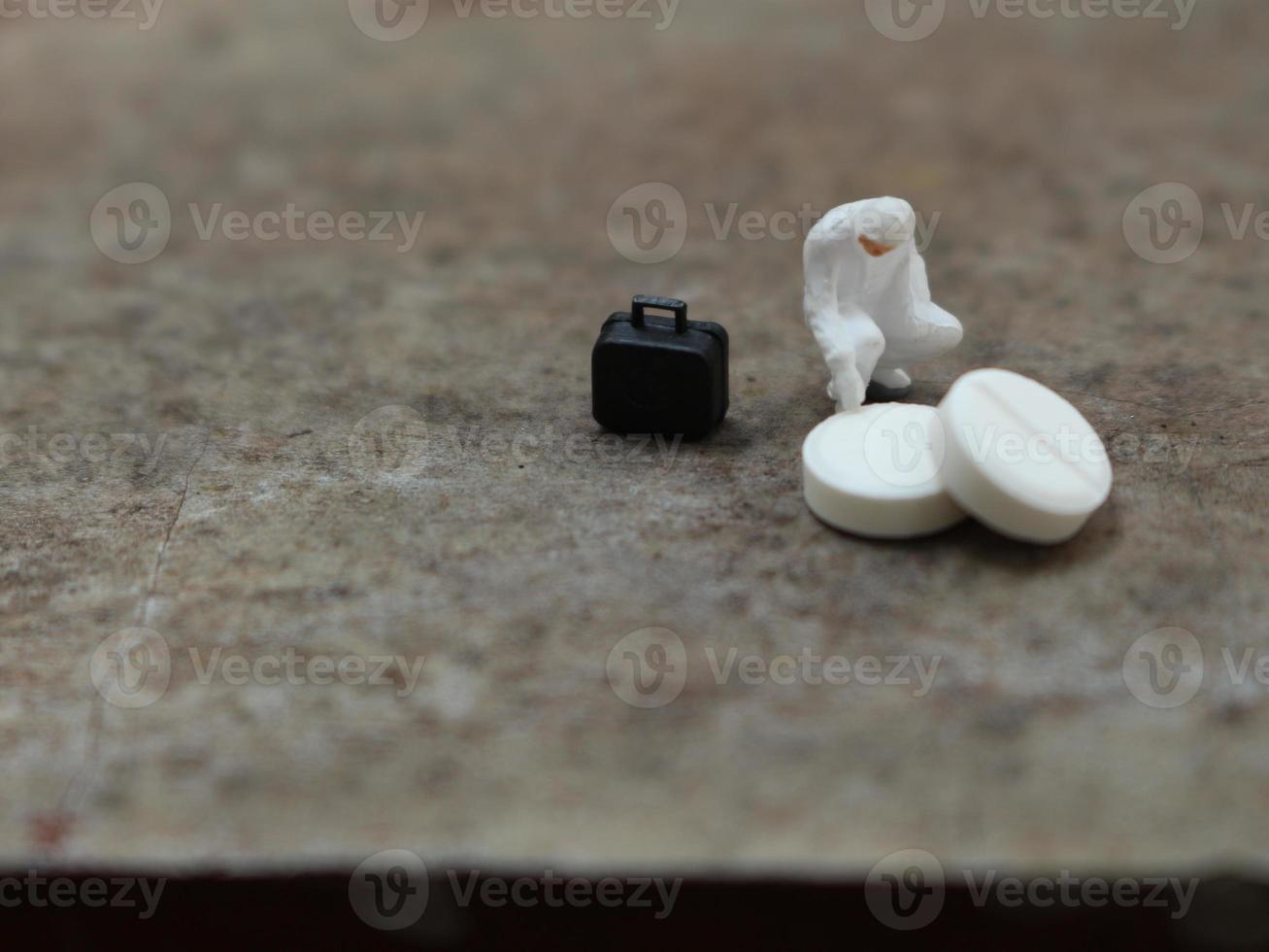 un' vicino su di un' miniatura figura di un' ricercatore ricercando un' droga. Salute foto concetto.