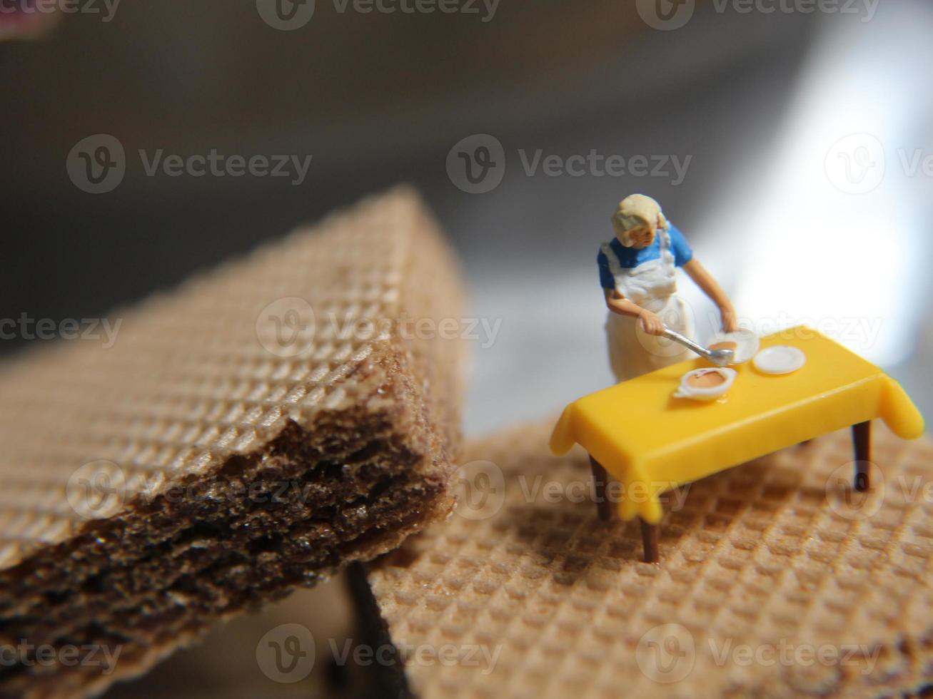 un' miniatura figura di un' donna cucinando su un' cioccolato wafer. foto