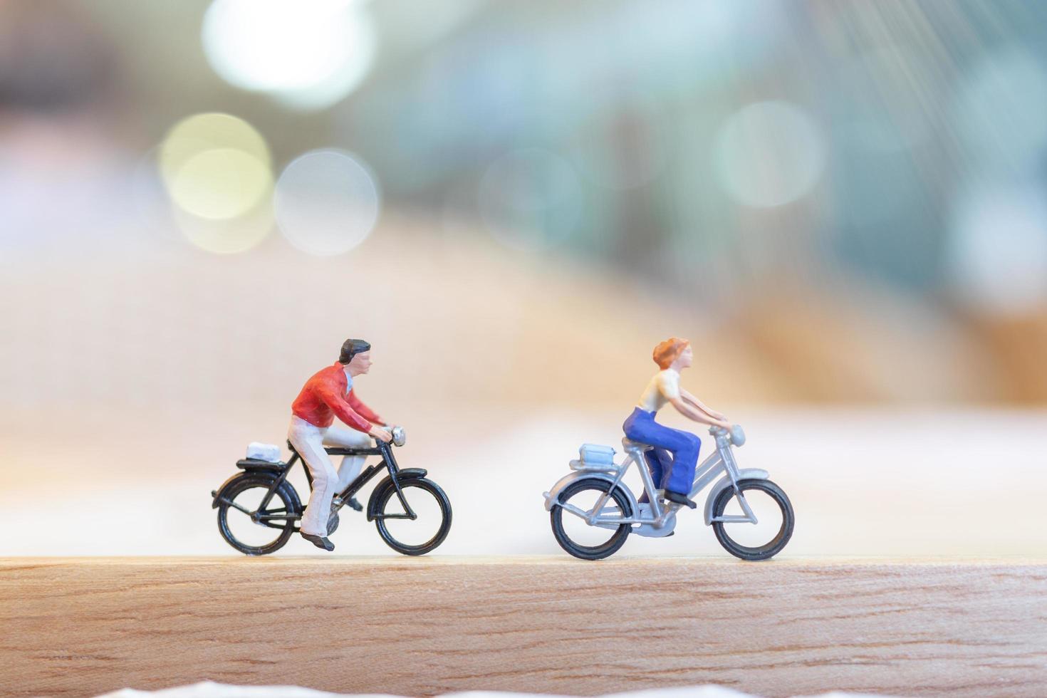 persone in miniatura in bicicletta su un ponte di legno, concetto di assistenza sanitaria foto