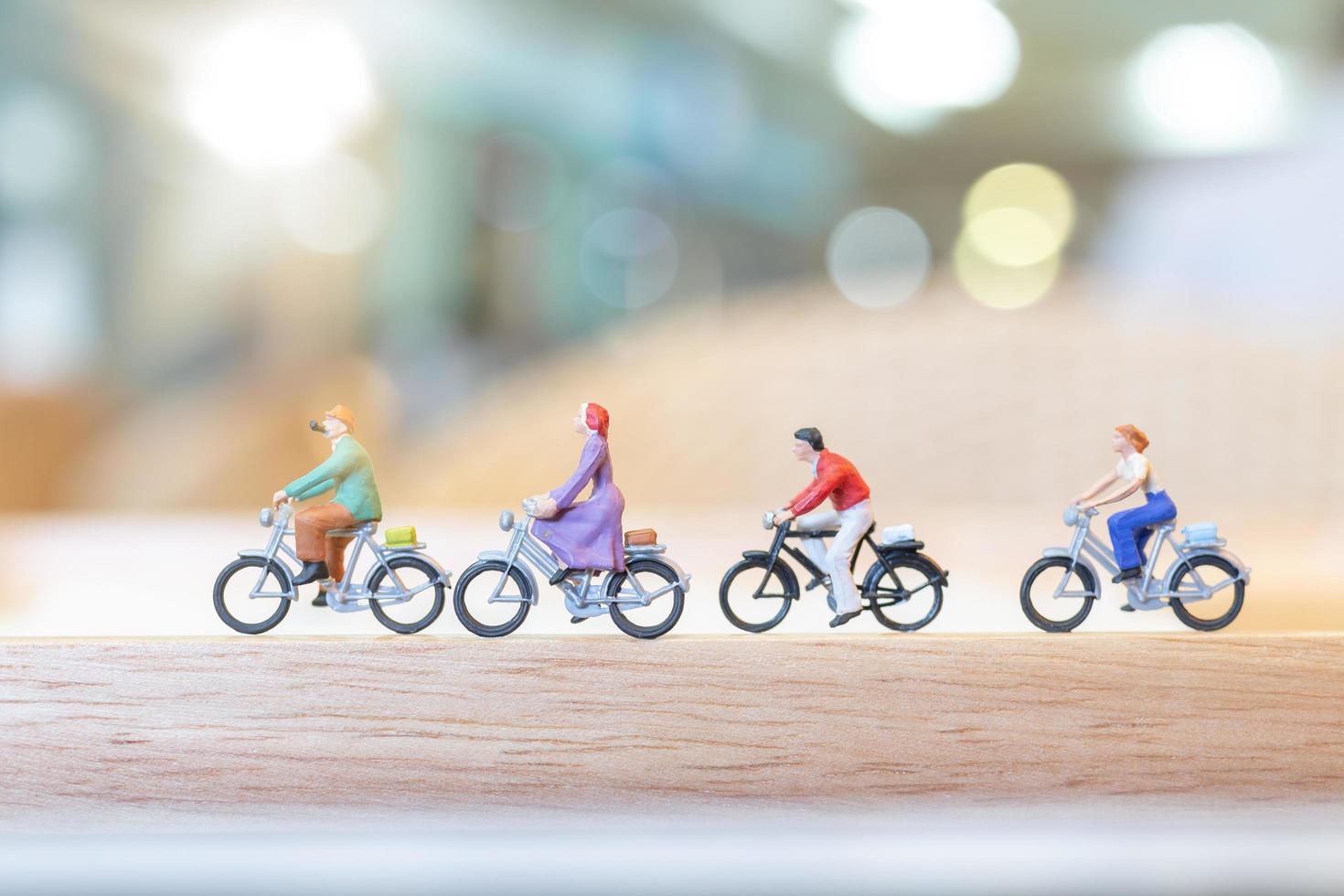 persone in miniatura in bicicletta su un ponte di legno, concetto di assistenza sanitaria foto