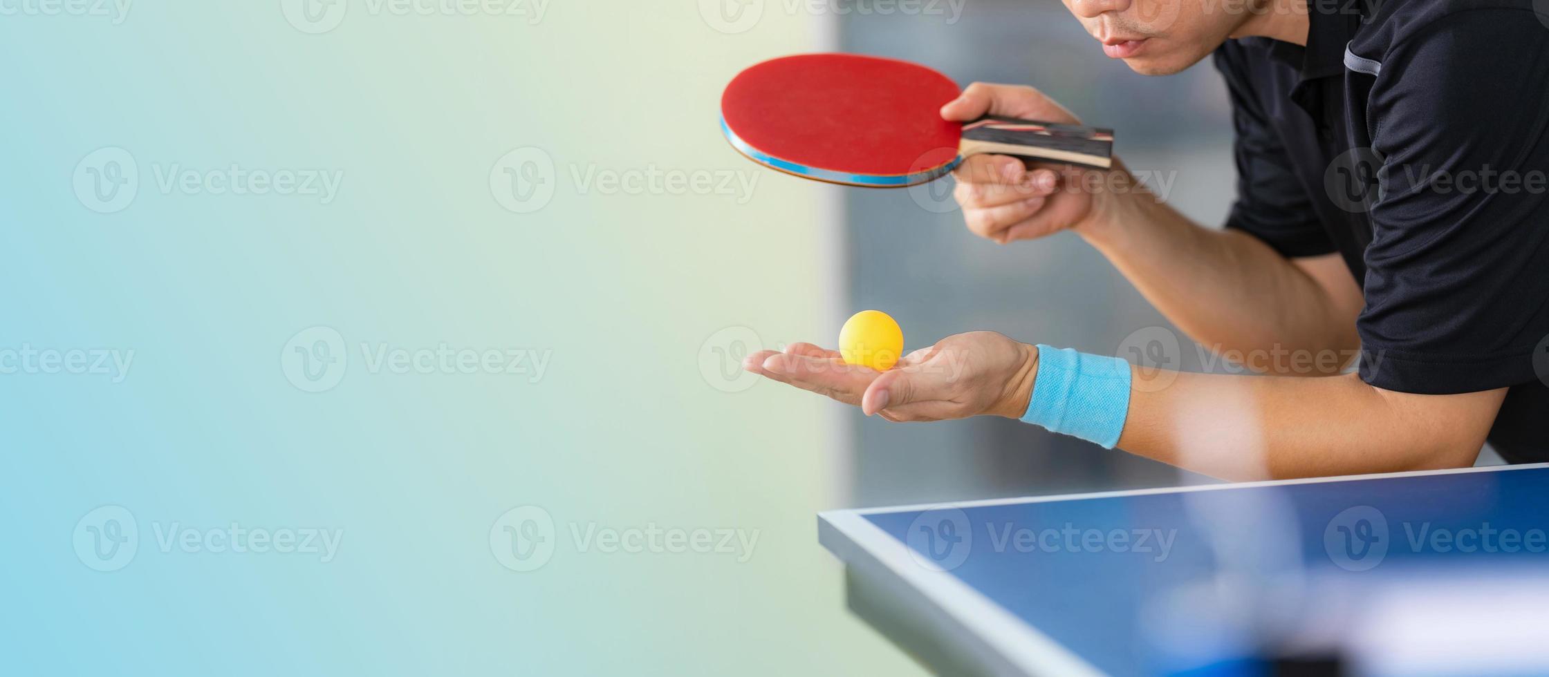 maschio giocando a ping pong con racchetta e palla in un palazzetto dello sport foto