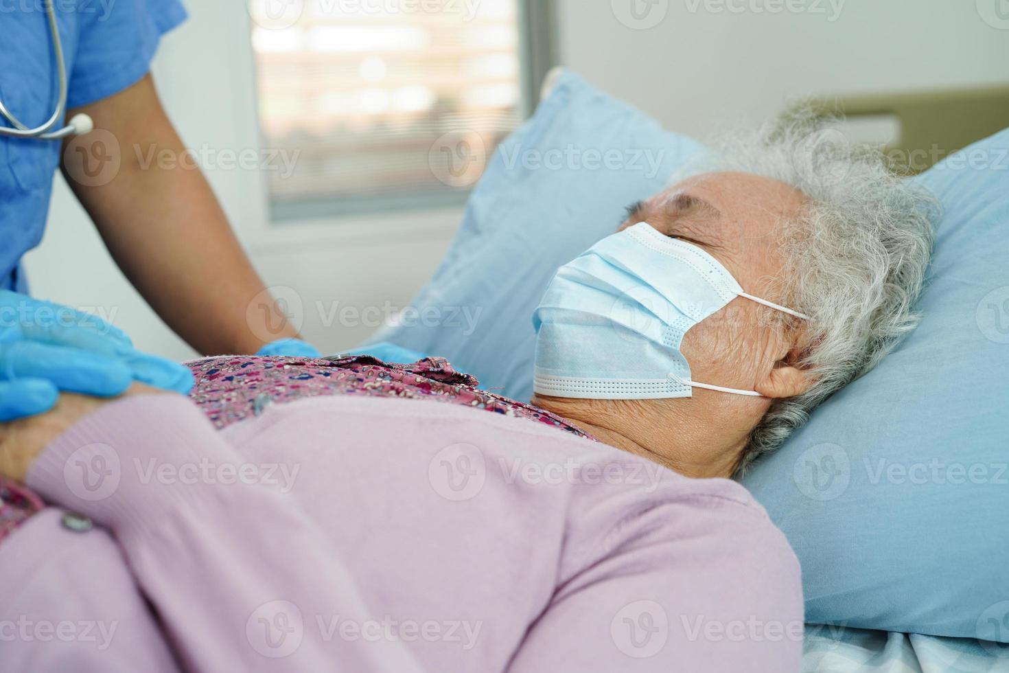 il medico controlla il paziente asiatico anziano della donna anziana che indossa una maschera per proteggere il coronavirus covid. foto