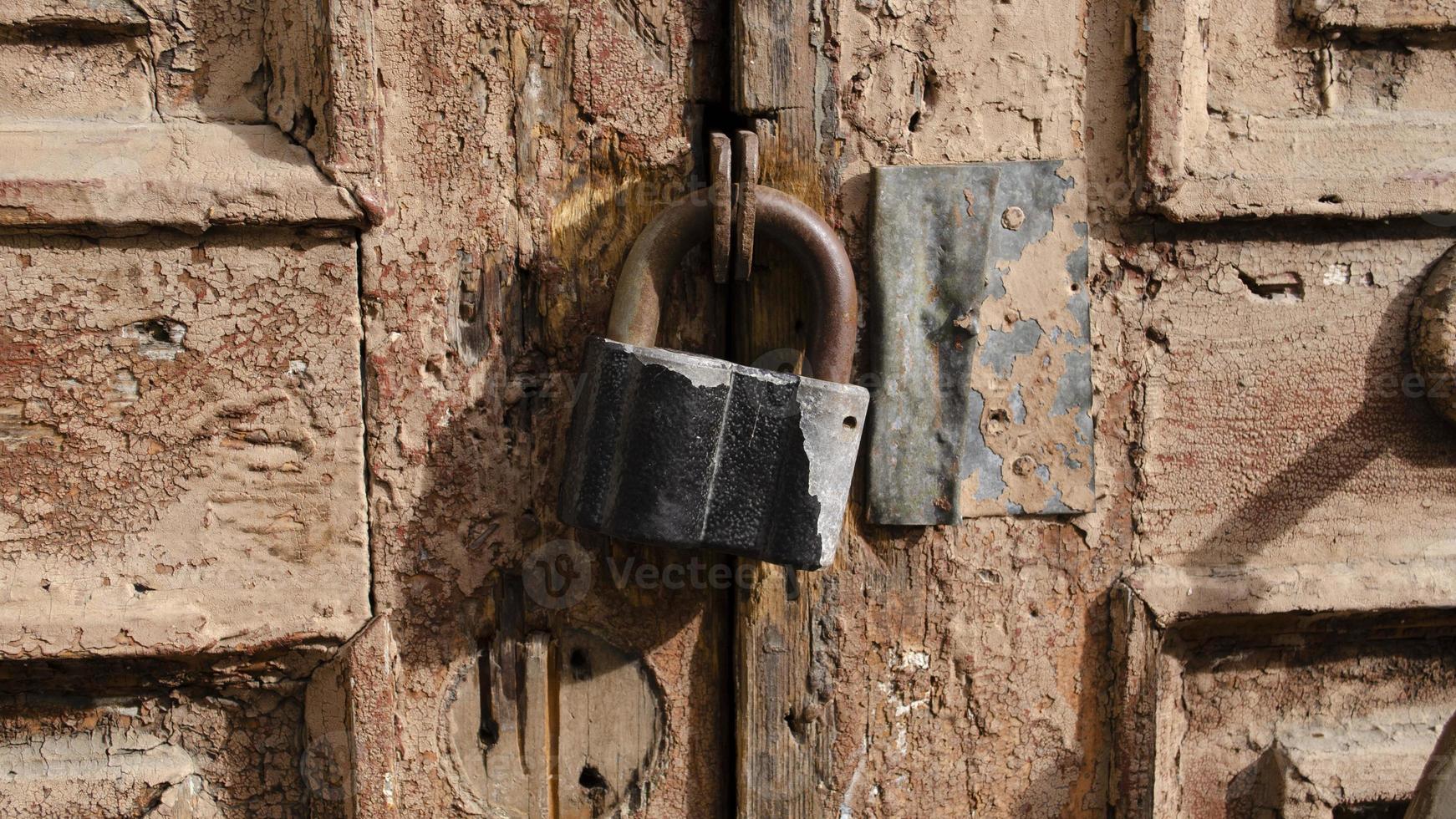 il serratura su il vecchio di legno porta avvicinamento. ruggine su il metallo serratura. peeling Marrone dipingere su il vecchio porta. antico struttura. foto