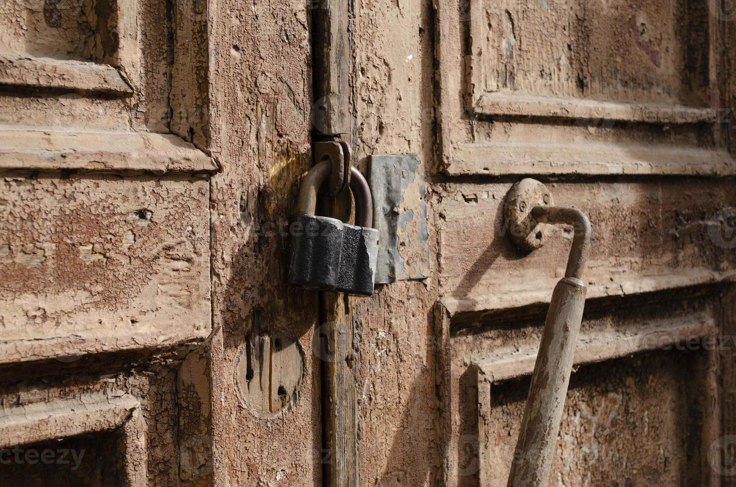 il serratura su il vecchio di legno porta avvicinamento. ruggine su il metallo serratura. peeling Marrone dipingere su il vecchio porta. antico struttura. foto