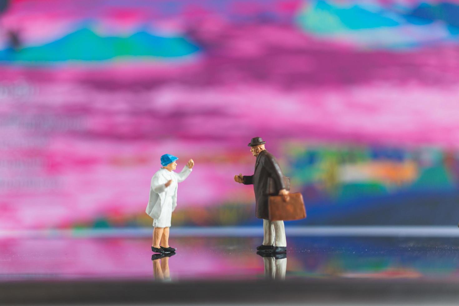 handshake di persone in miniatura su uno sfondo colorato foto