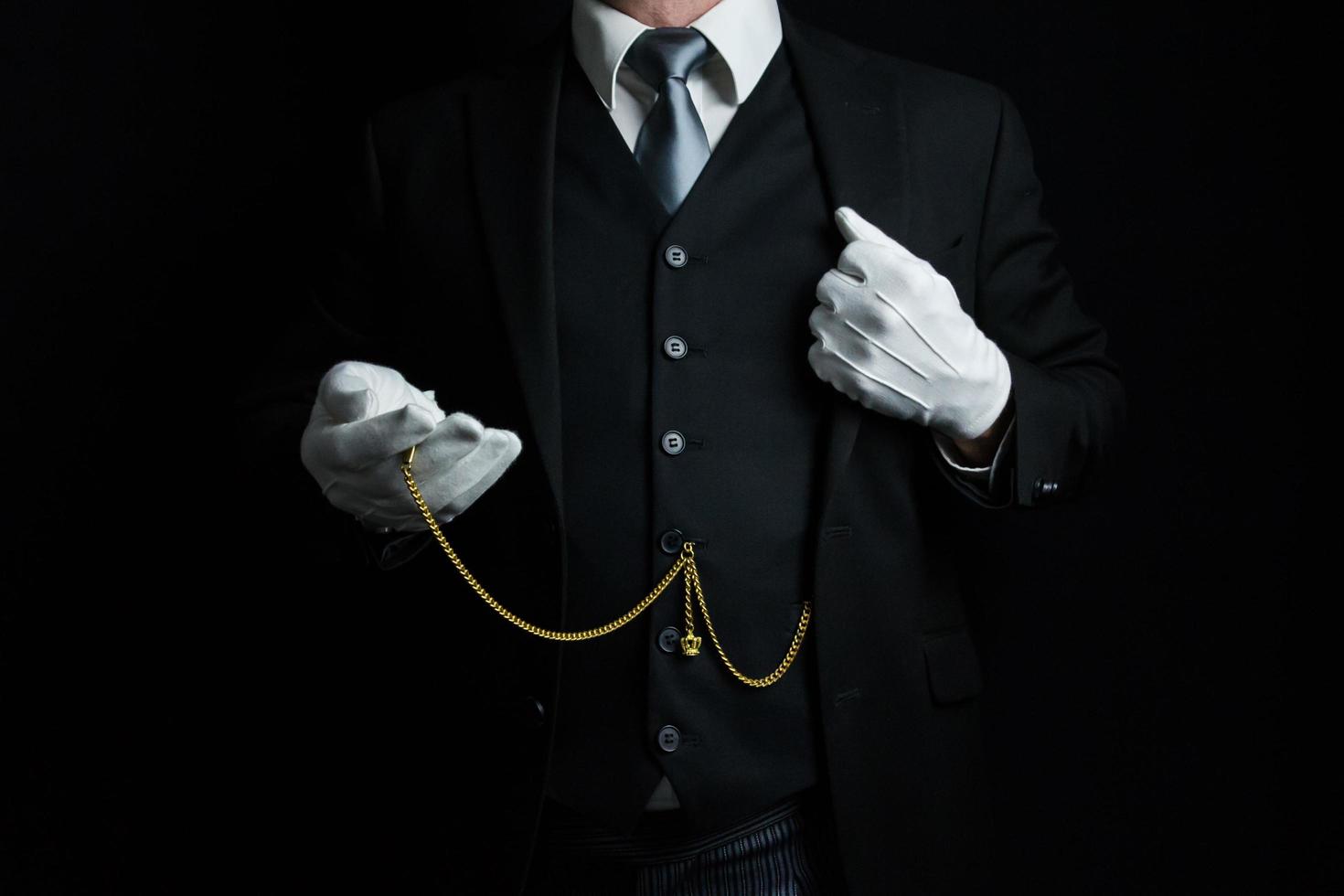 ritratto di maggiordomo nel buio completo da uomo e bianca guanti Tenere oro tasca guarda. Vintage ▾ stile e professionale cortesia. foto
