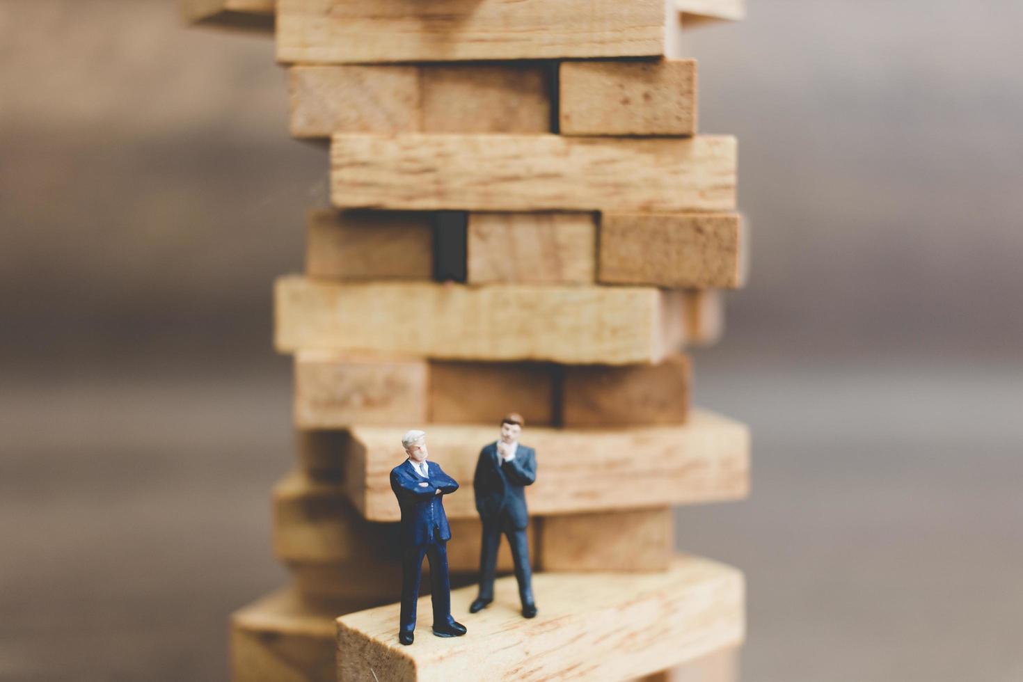 uomini d'affari in miniatura in piedi su blocchi di legno foto
