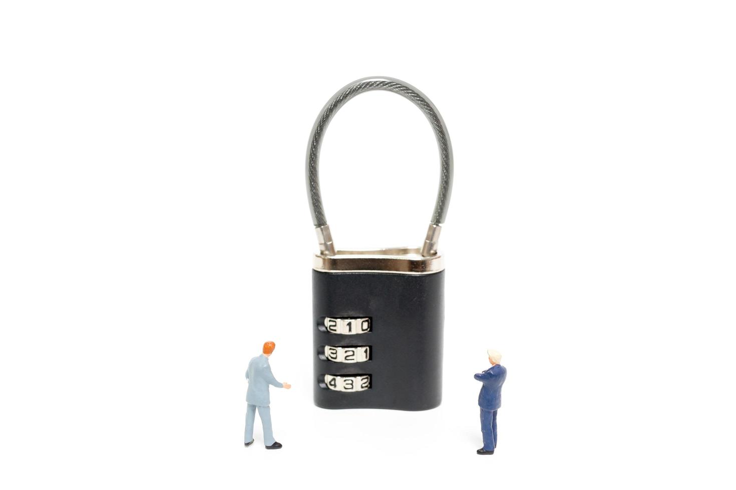 uomini d'affari in miniatura che aiutano a sbloccare la password su un lucchetto, concetto di soluzione aziendale foto