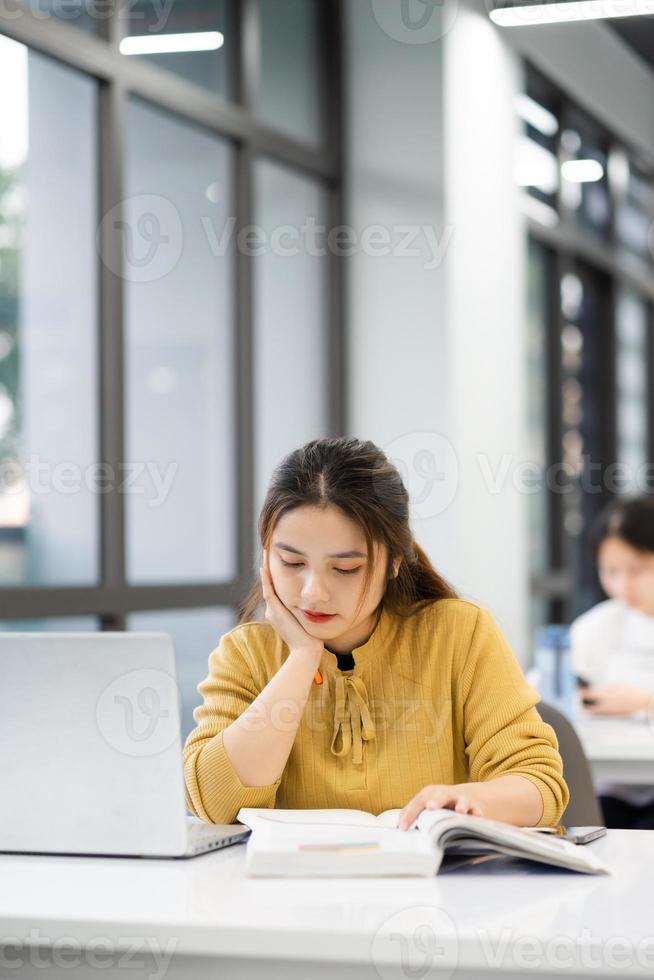 ritratto di asiatico femmina alunno studiando a Università biblioteca foto