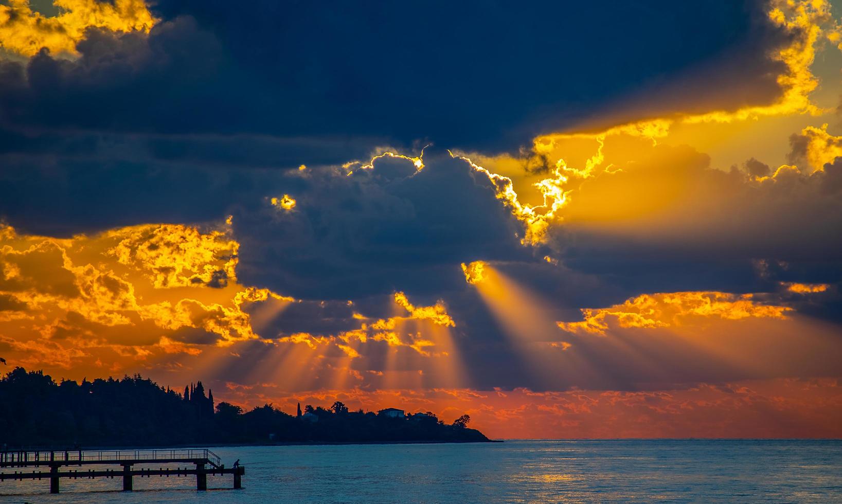 vista sul mare con un tramonto nuvoloso arancione foto