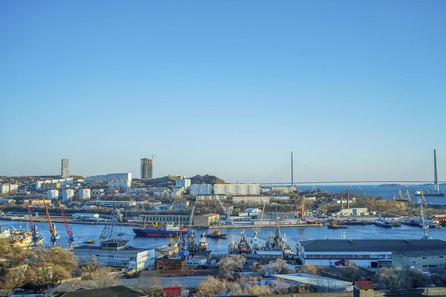 paesaggio urbano di un porto e il ponte russo con un cielo blu chiaro a vladivostok, russia foto