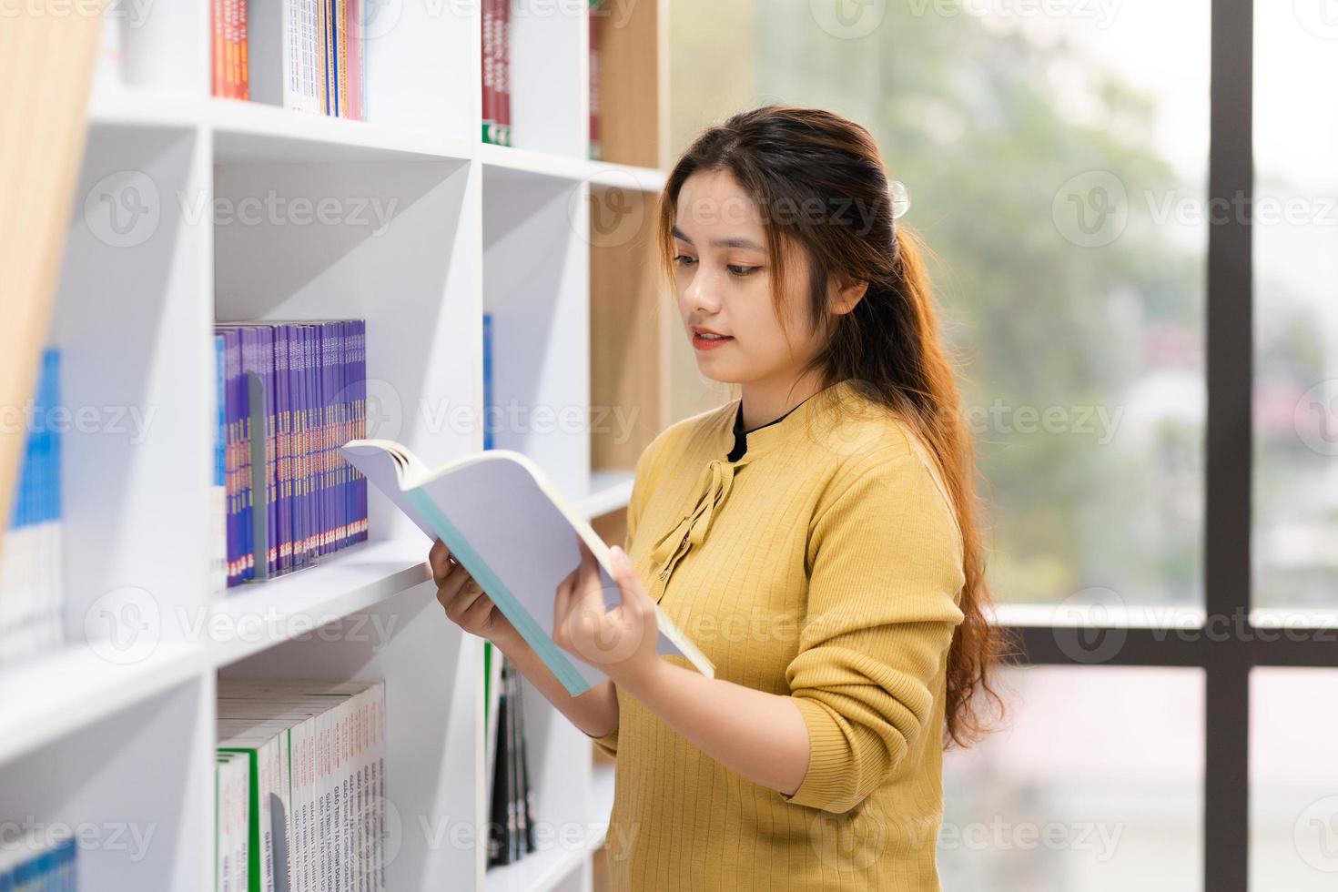 ritratto di asiatico femmina alunno studiando a Università biblioteca foto