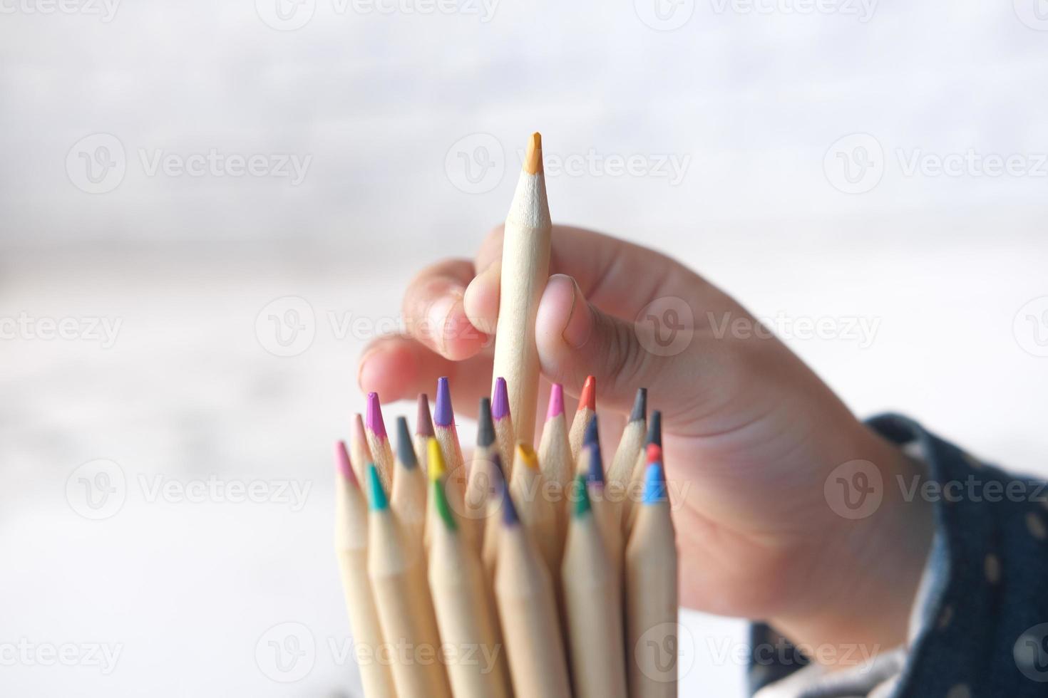 ragazza del bambino che seleziona una matita colorata da una scatola foto