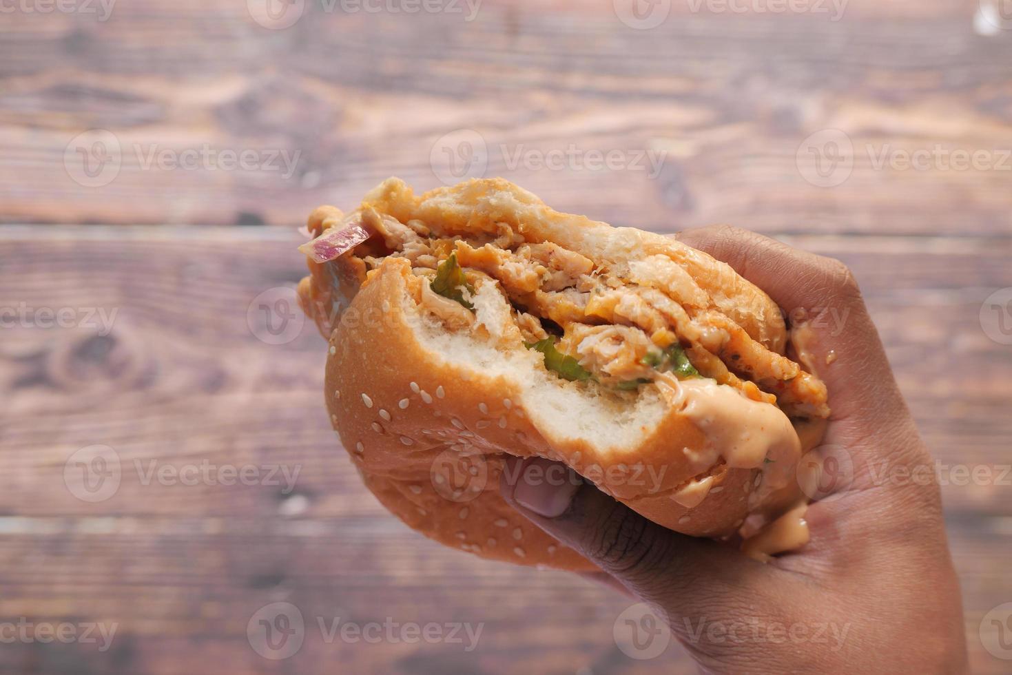 mano che tiene un panino mezzo mangiato foto