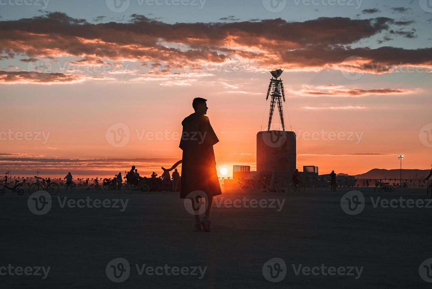 persone a piedi in direzione tramonto a un' Festival nel il deserto a il ardente uomo Festival. foto