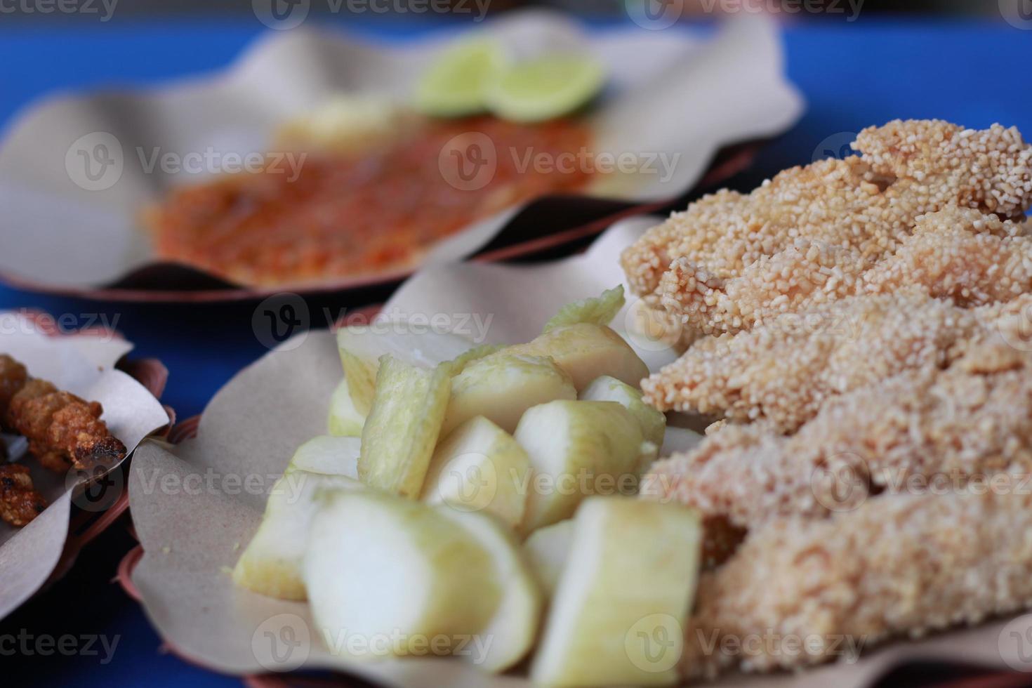foto di pollo satay impanato e servito con rosso chili salsa. indonesiano cibo chiamato saziare taichan. cibo concetto foto.