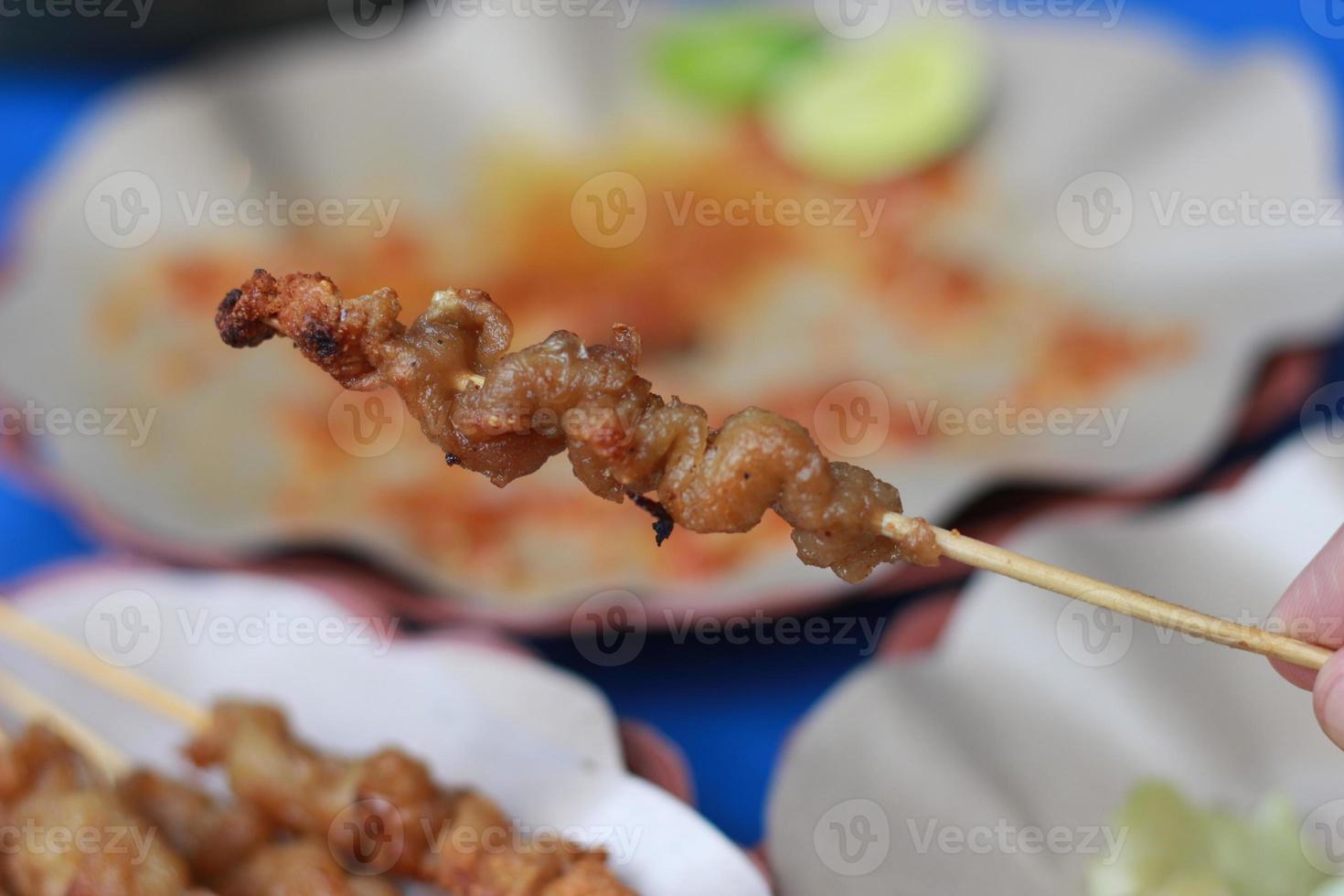 foto di pollo intestino satay e servito con rosso chili salsa. indonesiano cibo chiamato saziare taichan. cibo concetto foto.