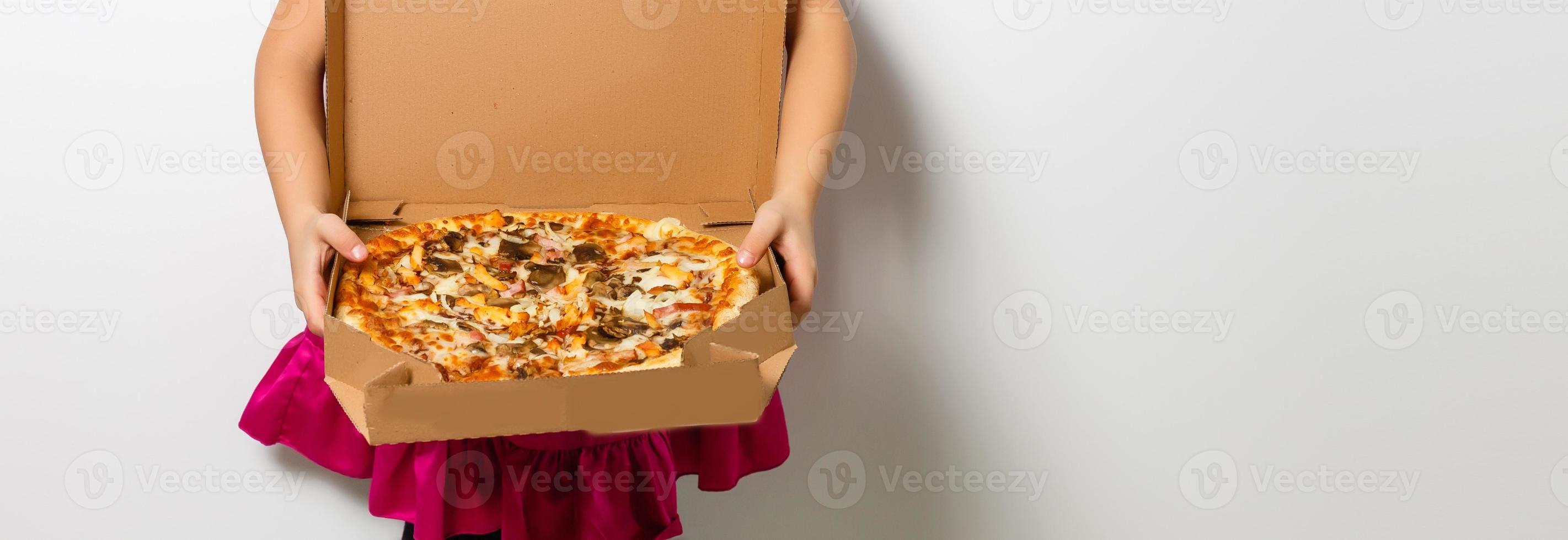 contento poco ragazza con Pizza nel un' carta scatola foto