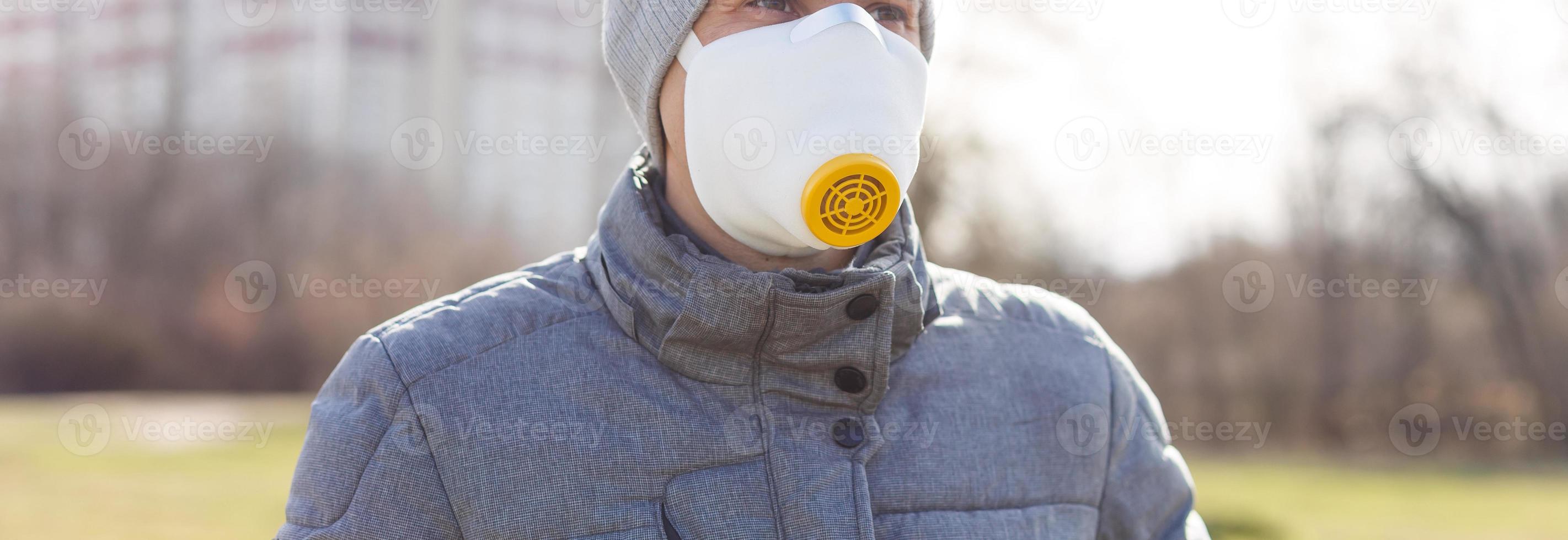 un' uomo indossare un' maschera su il strada. protezione contro virus e presa foto