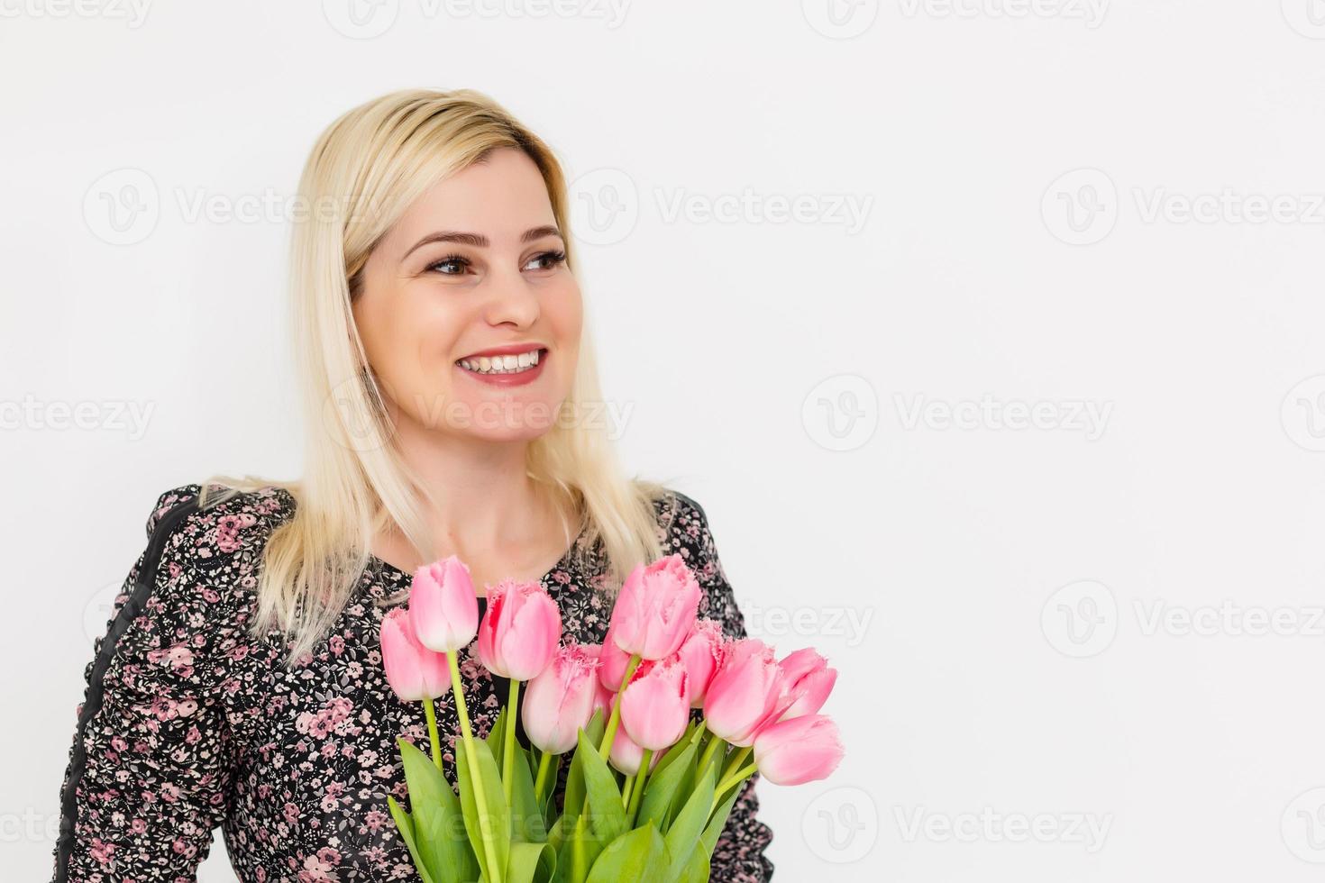 ritratto di un' bellissimo giovane ragazza nel vestito Tenere grande mazzo di tulipani al di sopra di bianca sfondo foto