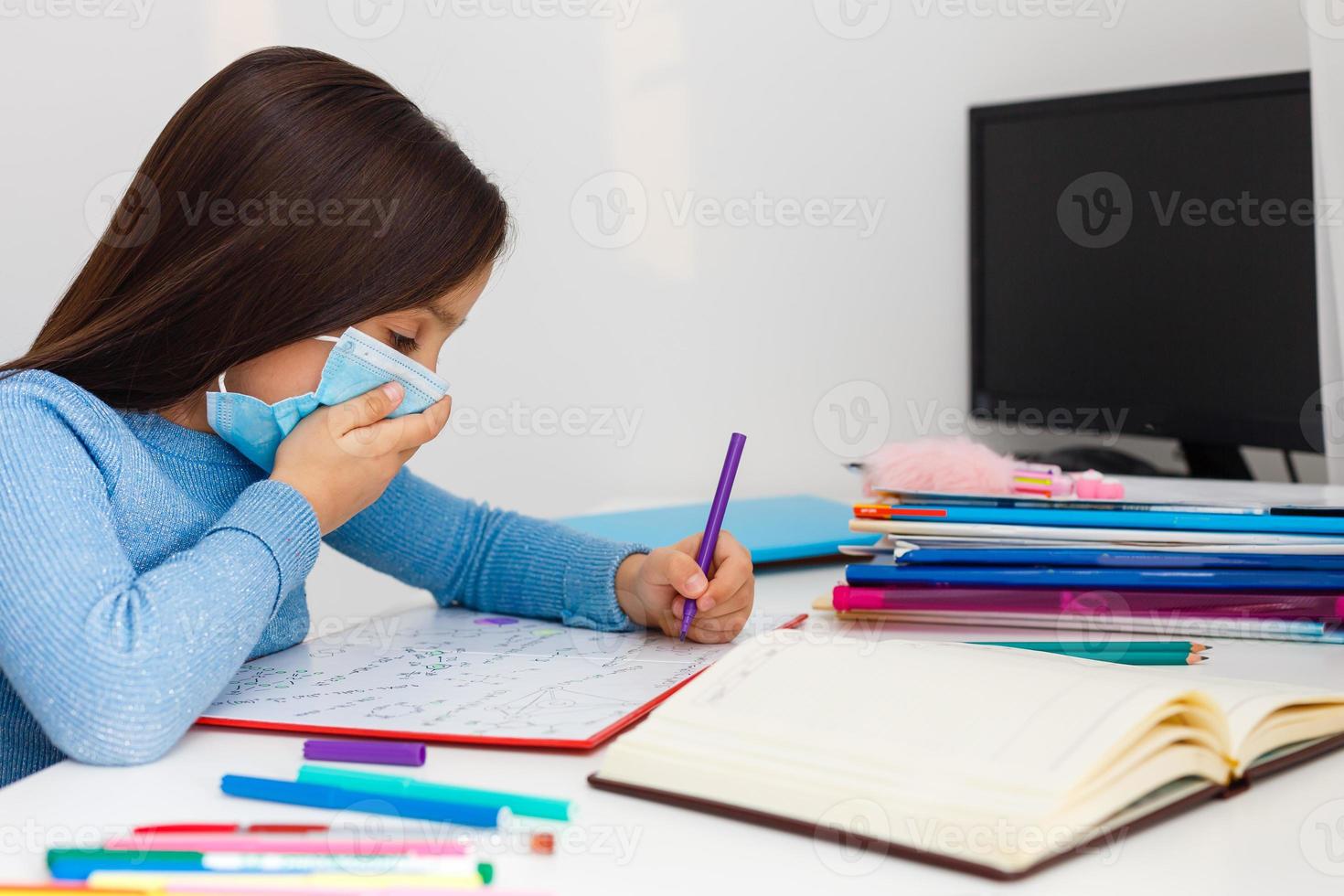 digitale tecnologia formazione scolastica concetto. poco ragazza nel un' protettivo maschera a distanza casa scolarizzazione, quarantena foto