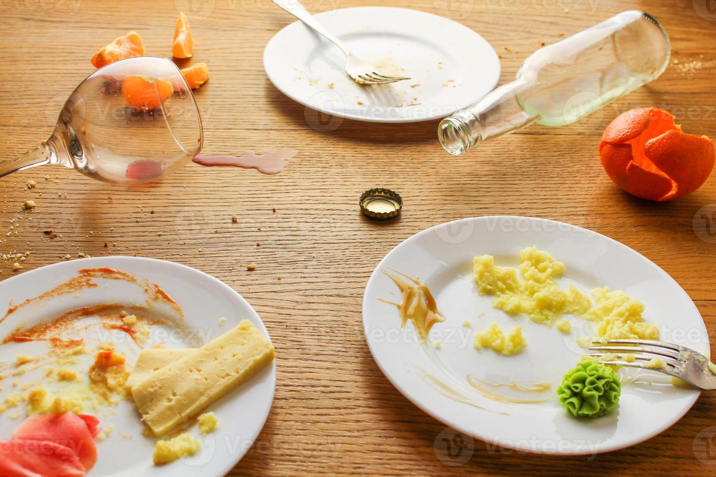 disordinato tavolo dopo festa. avanzi cibo, rovesciato bevande, sporco piatti. foto