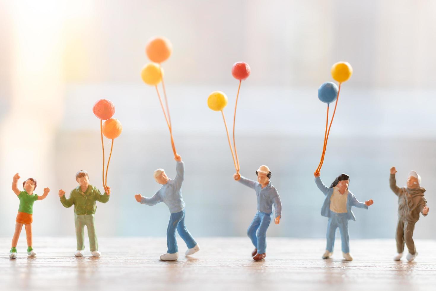 persone in miniatura che camminano con palloncini, concetto di famiglia felice foto