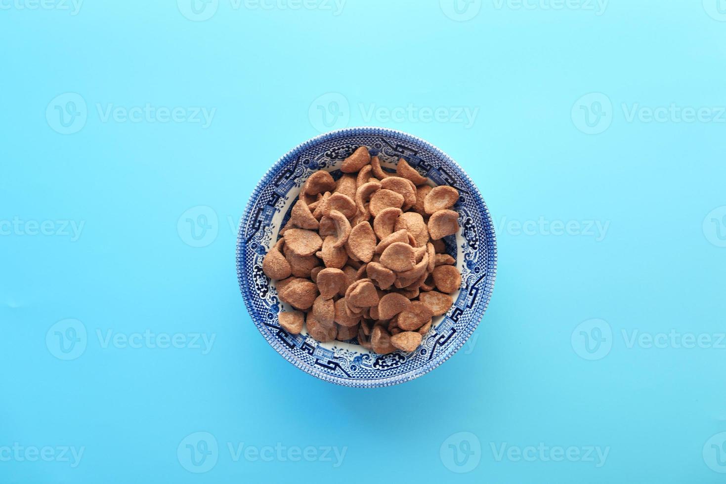 vista dall'alto di fiocchi di mais al cioccolato in una ciotola su sfondo blu foto